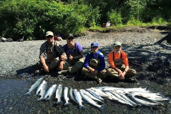  family sitting with freshly caught fish strewn out in front of them